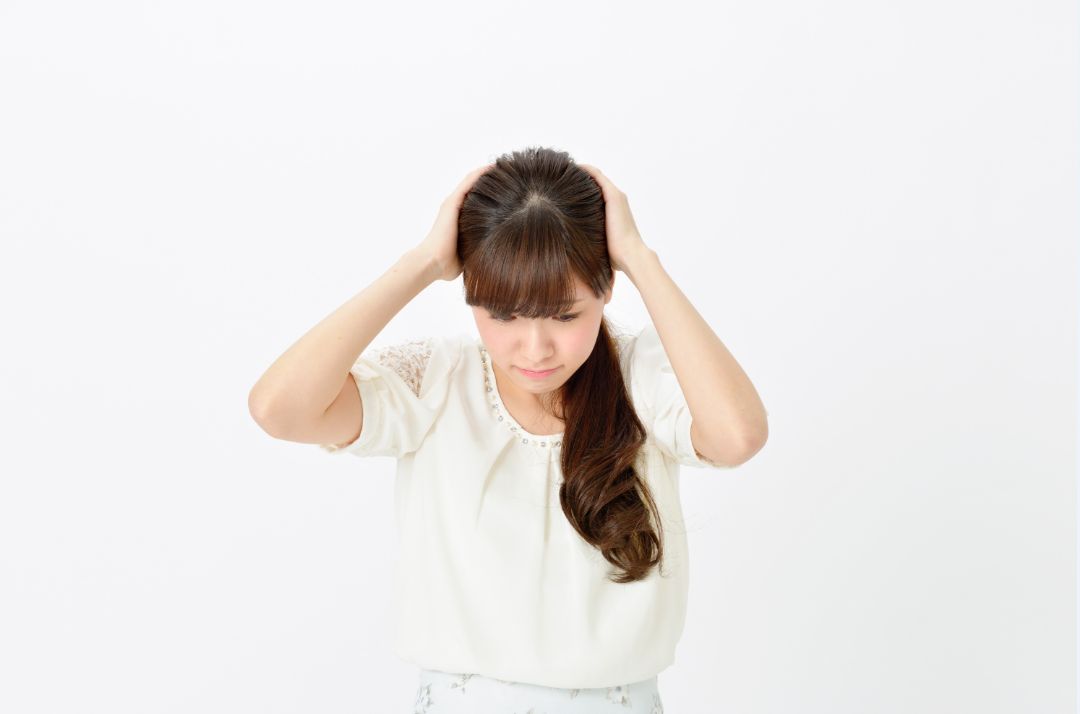 服のネット通販に失敗して頭を抱える女性
